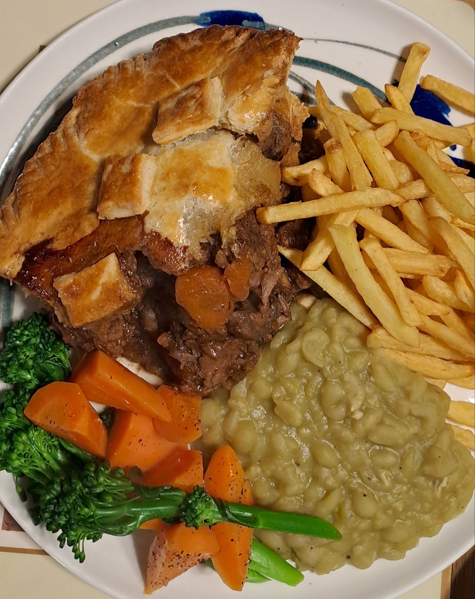 Beef and Guinness pie with buttered vegetables and mushy peas